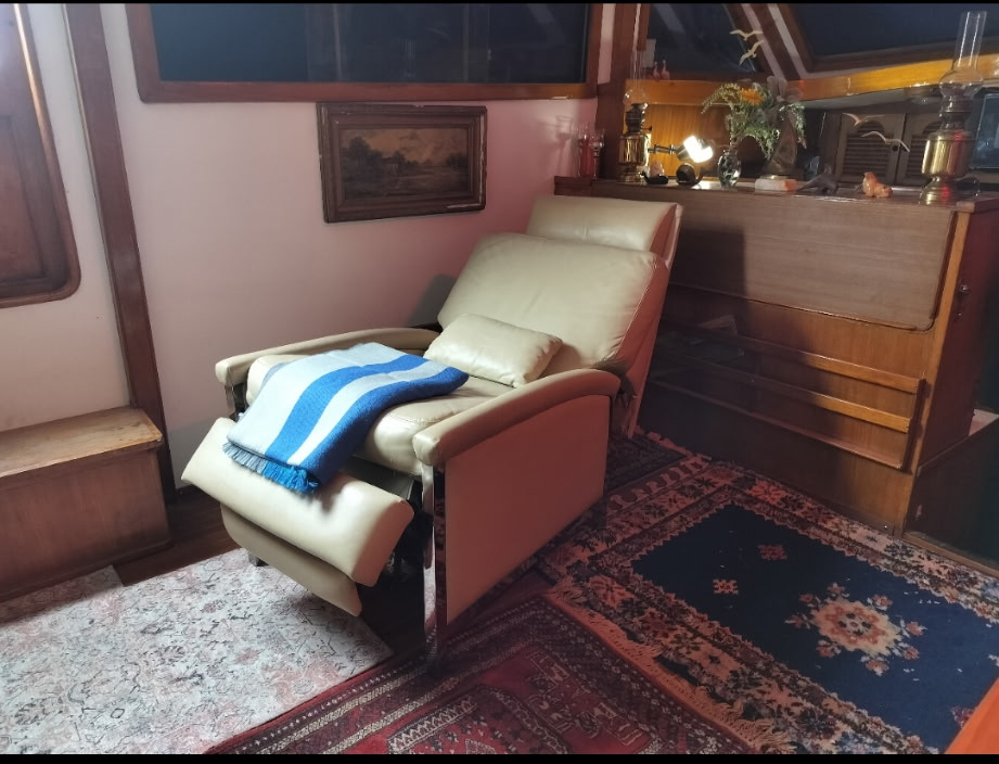 Plush reclining chair in hypnotherapy office aboard boat Harmony for healing hypnosis session.